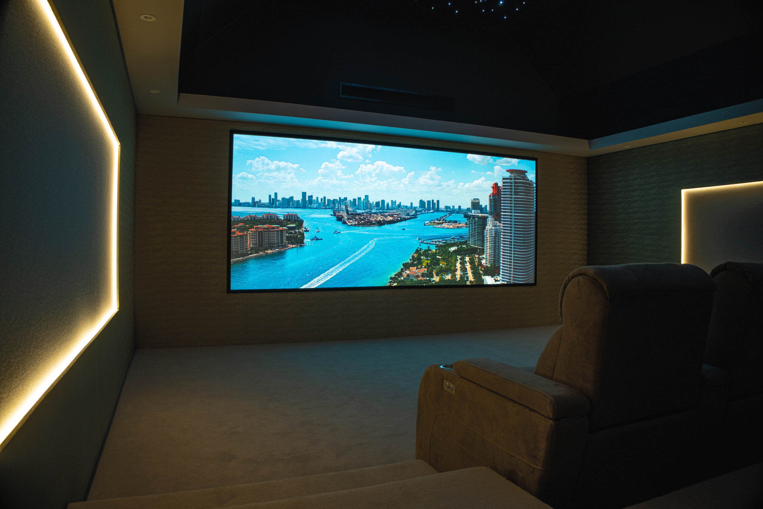 Luxury home cinema in Wynyard Park featuring a large projection screen, tiered seating and ambient wall lighting