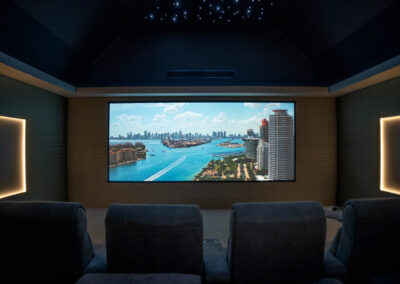 Wide-angle view of the Wynyard Park cinema room showing tiered premium seating and a large screen with backlit wall panels.