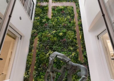 Smart lighting illuminating a green living wall in a Cadogan Place atrium, with sculptural artwork and luxury home design